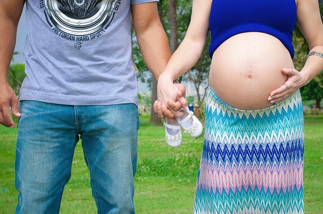 Pregnant couple holding hands