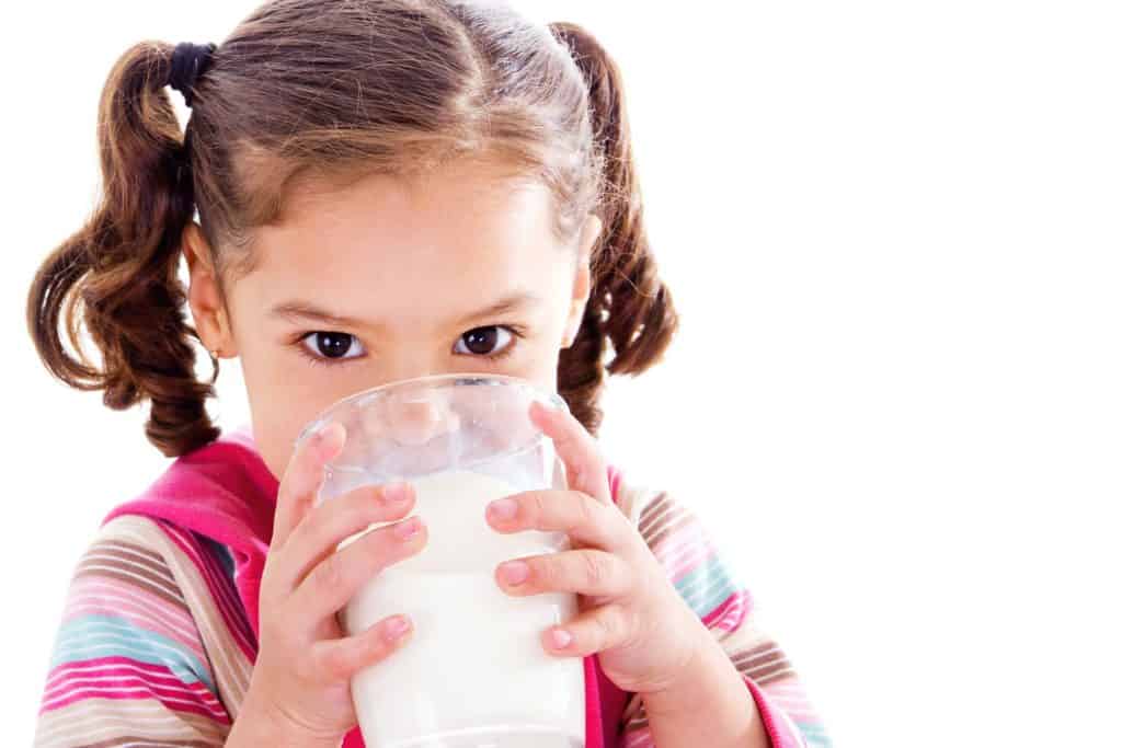 Girl drinking a glass of milk to show it could be causing her eczema